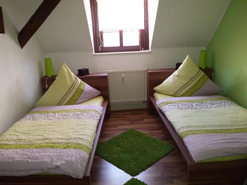 Duas camas num pequeno quarto com uma janela em 4 JahresZeiten em Meissen