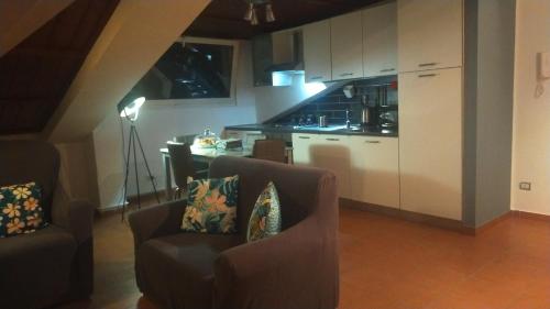 a living room with two chairs and a kitchen at Loft Belvedere in Sulmona