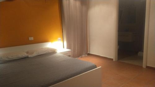 a bedroom with a bed and a yellow wall at Loft Belvedere in Sulmona