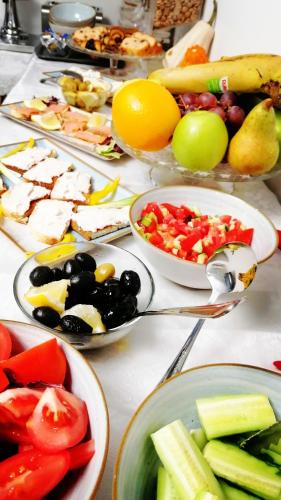 a table full of plates of food with fruits and vegetables at Lina Hotel in Bucharest