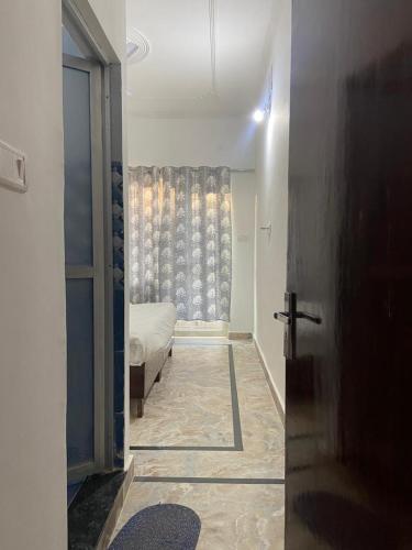 a hallway with a bed and a window in a room at Karma Hostel in Khajurāho
