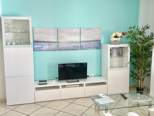 una sala de estar con TV en un centro de entretenimiento blanco en Grande appartamento Tenerife Los Abrigos, en Los Abrigos