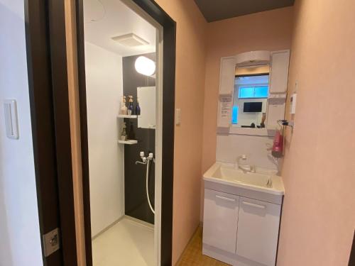 a small bathroom with a sink and a shower at Higashi Shimbashi Building 3F Hostel Gion SORA - Vacation STAY 92728v in Kyoto