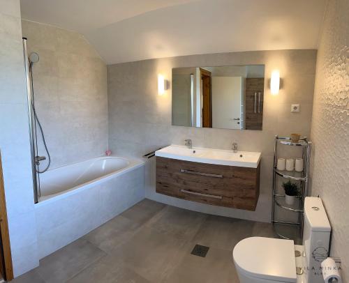 a bathroom with a tub and a sink and a toilet at Vila Minka Bled - Perfect Family Vacation Home in Bled