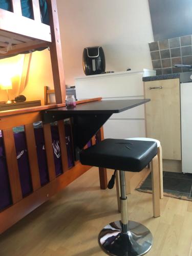 a desk with a chair in a room with a bunk bed at Hazelcroft Guest House in London