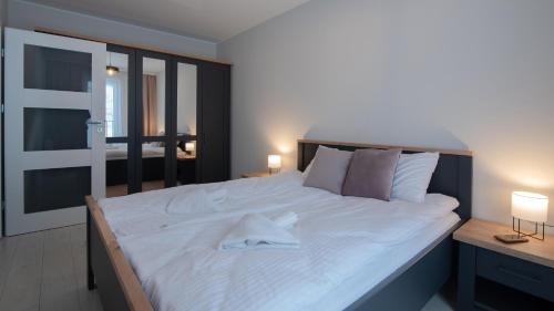 ein großes weißes Bett mit einem weißen Handtuch drauf in der Unterkunft Apartament Spokojna 18 in Wisła