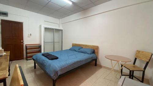 um quarto com uma cama e uma mesa em ธนทรัพย์ อพาร์ทเม้นท์ Room03 em Ban Bang Kadi Pathum Thani