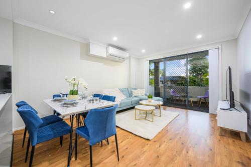 a living room with a table and blue chairs at Parramatta New 2Bedroom apt close to TrainShoping in Sydney