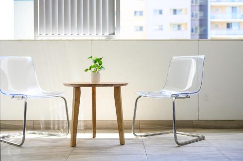 two white chairs and a table with a potted plant on it at Liverpool Stunny Modern Apt Wifi &Parking in Liverpool