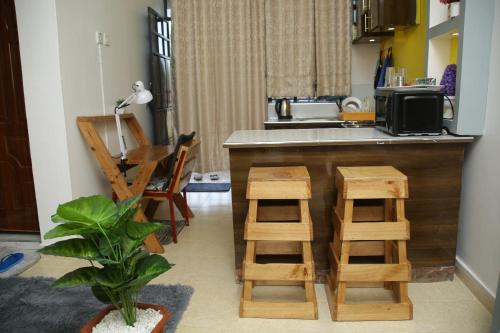 a kitchen with a counter and some wooden stools at EnZ 6 lovely Apartments in Bungoma