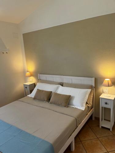 a bedroom with a large bed with two night stands at Villa Elma in Villaputzu