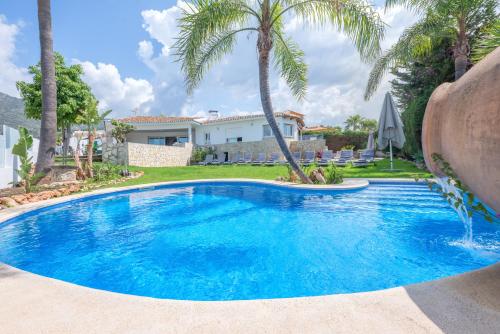 ein Pool vor einem Haus mit Palmen in der Unterkunft Villa Jazz Marbella with 7 bedrooms in Marbella