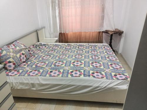 a bed with a quilt on it in a bedroom at Bahçeli Ev Müstakil in Burhaniye