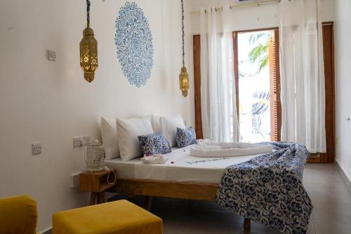 a bedroom with a bed with a table and a window at Pili Pili Orient Beach Hotel in Bwejuu