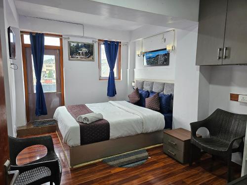 a bedroom with a large bed with blue curtains at Royal Vista - Guest House in Darjeeling