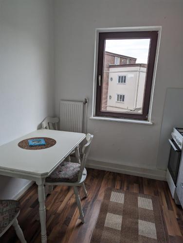 a table and chairs in a room with a window at Gästehaus Gröpelingen in Bremen