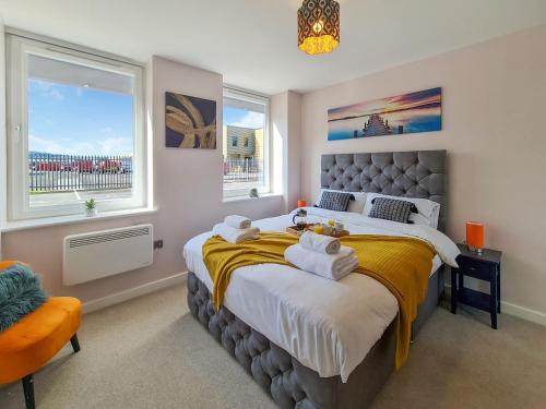 a bedroom with a large bed with towels on it at The Post House Green by Fortuna Property Portfolio in Gloucester