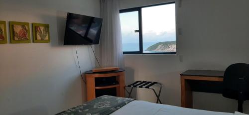 a bedroom with a bed and a desk and a television at Natal Plaza requinte, conforto e vista para o mar in Natal