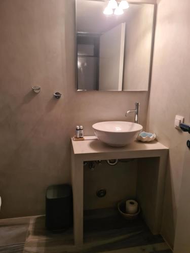 Greco Hotel في هيدرا: حمام مع حوض ومرآة