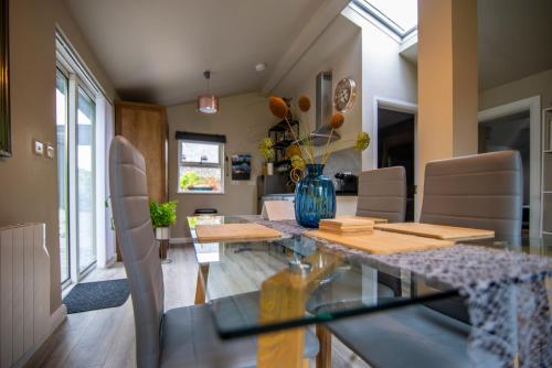 a dining room with a glass table with a vase on it at The Rose Suite Kenmare in Kenmare