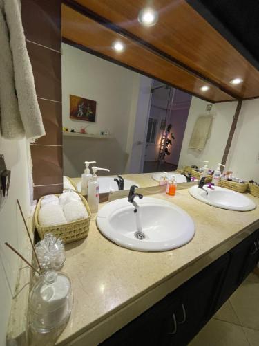 a bathroom with two sinks and a large mirror at chambre privée in Kenitra