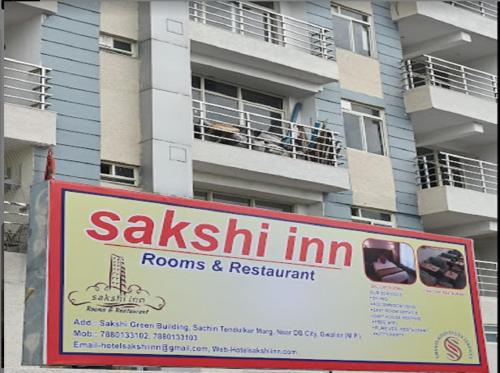 a sign in front of a apartment building at Hotel Sakshi Inn Rooms and Restaurant in Gwalior