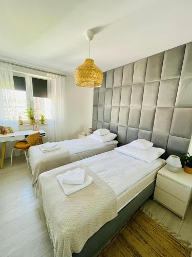 a bedroom with two beds and a padded wall at BeeApartments Naściszowska 18 in Nowy Sącz