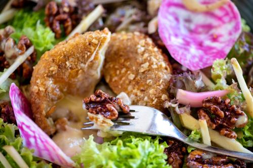 a salad with a fork in a bowl of food at PAPILL'ON - Boutique Hotel in La Tzoumaz