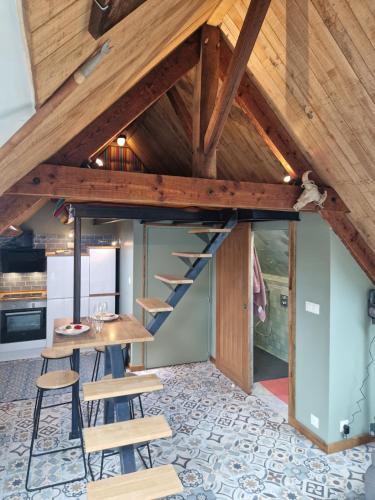 a room with a staircase and a table and chairs at le perchoir a 500m des plages in Cancale