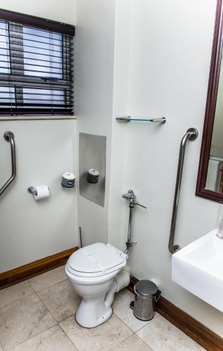 a bathroom with a toilet and a sink at Belaire Suites Hotel in Durban