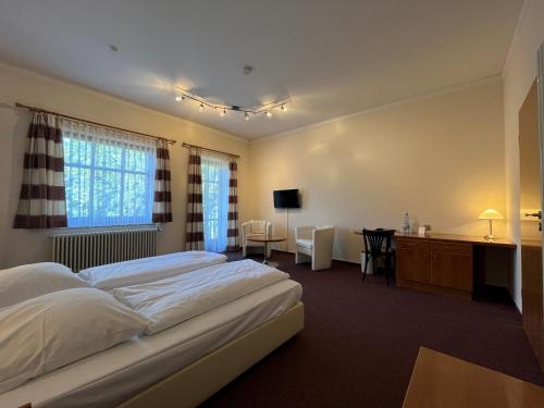 una camera d'albergo con 2 letti e una scrivania di Hotel Liszt a Weimar