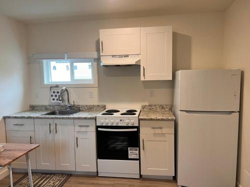 a kitchen with white appliances and a white refrigerator at Studio apartment in Cranbrook