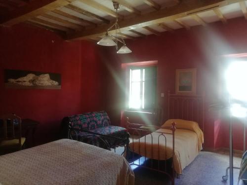 a bedroom with red walls and a bed and a window at La Torre di Pieve in Pieve Santo Stefano