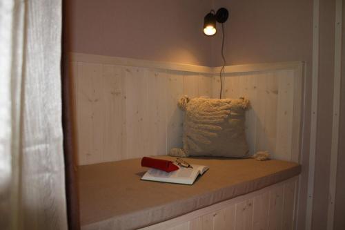 una cama con una almohada y un libro sobre ella en Kikelet Udvarház en Zánka