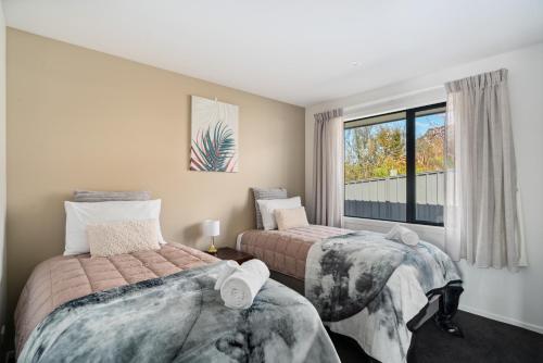 a bedroom with two beds and a window at Holiday in a paradise in Wanaka