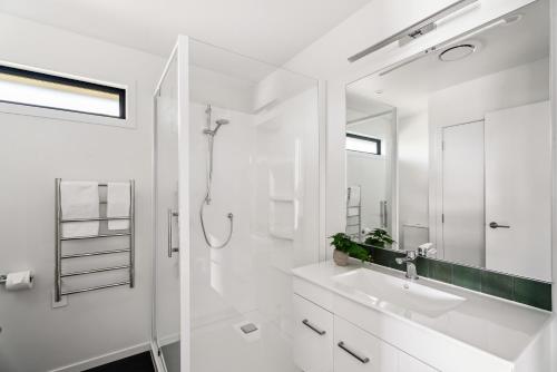 a white bathroom with a sink and a mirror at Holiday in a paradise in Wanaka
