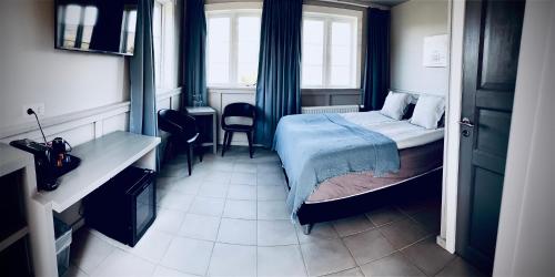 um pequeno quarto com uma cama e uma janela em Hraunsnef Country Hotel em Bifrost