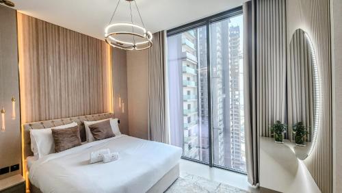 een slaapkamer met een wit bed en een groot raam bij STAY BY LATINEM Luxury 2BR Holiday Home CV A2301 near Burj Khalifa in Dubai