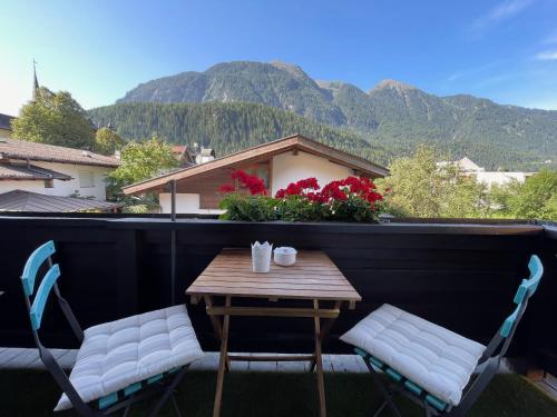 a table and chairs on a balcony with mountains in the background at Haus Gertraud in Oetz