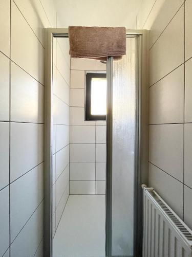 a walk in shower in a room with white tiles at Haus Gertraud in Oetz