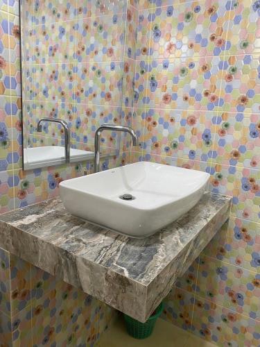 lavabo blanco en una encimera de mármol en el baño en bom bomm home for lovery en Bangna