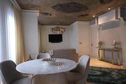 een eetkamer met een witte tafel en stoelen bij AB Residences -Cihangir Luxury Antique Apartment in Istanbul
