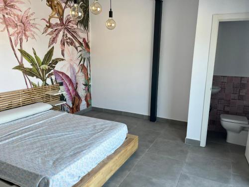1 dormitorio con cama y pared de flores en Chalet en Montellano (Sevilla), en Montellano