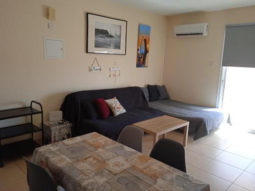 een woonkamer met een bank en een tafel bij Xylophagou Larnaca Ayia Napa 1 bedroom apartment in Xylophaghou