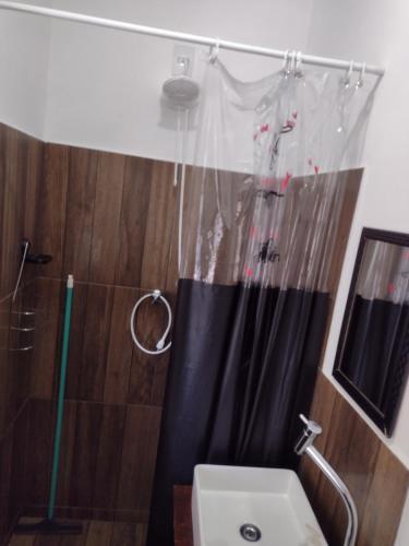a shower with a black shower curtain and a sink at Casa Mariano in Brotas