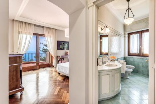 łazienka z łóżkiem, umywalką i wanną w obiekcie Villa Solatia w mieście Massa Lubrense
