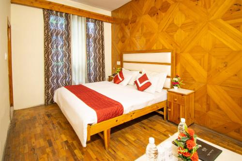 a bedroom with a bed and a wooden wall at Octave Himalayan Hamlet in Kulu