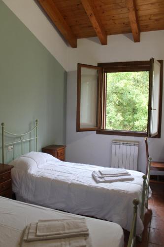 1 dormitorio con 2 camas y ventana en La Rizza, en Bentivoglio