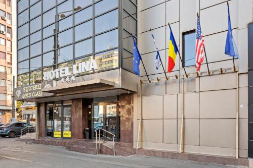 a building with flags in front of it at Lina Hotel in Bucharest