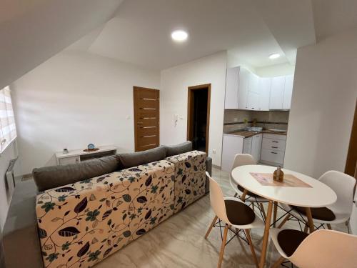 ein Wohnzimmer mit einem Sofa und einem Tisch in der Unterkunft Apartman Vuk Zlatar in Brdo